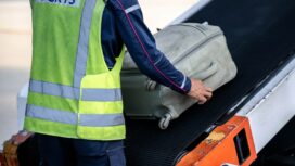 This picture taken on September 3, 2024 shows a staff member transferring baggages into a Cathay Pacific flight for departure in Kansai International Airport of Osaka Prefecture. - Kansai International Airport in Japan can't be held responsible for the less superlative performance of airlines or other stops in a traveller's journey, but it claims its handlers never lose a bag. (Photo by Philip FONG / AFP) / TO GO WITH:  JAPAN-AVIATION-AIRPORT