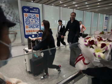 FILE- Passengers walk out of the International arrival hall of the Beijing Capital International Airport in Beijing, March 14, 2023. (AP Photo/Ng Han Guan, File)