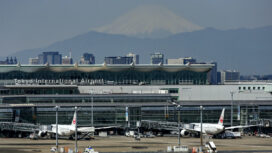 Planes are parked at gates at Tokyo Haneda International Airport as Mount Fuji appears Tuesday, May 4, 2021, in Tokyo. Tokyo and the western metropolises of Osaka, Kyoto and Hyogo, home to about a quarter of Japan's population of 126 million, are under the latest 17-day state of emergency as the variant, detected earlier in Britain, is rapidly spreading among younger people, causing more serious cases. People are discouraged to travel during Japan's 