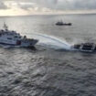 In this image made from a video provided by the National Task Force for the West Philippine Sea (NTF-WPS), a Chinese coast guard vessel, left, fires a powerful water cannon on a Philippine bureau of fisheries vessel near a disputed shoal in the South China Sea Wednesday Dec. 4, 2024. (National Task Force for the West Philippine Sea via AP)