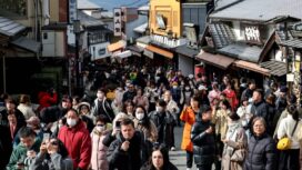 Tourists walk past shops and restaurants up the hill leading to Kiyomizu-dera Temple in Kyoto on Jan. 13. Photographer: Paul Miller/AFP/Getty Images