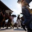 Passersby holding umbrellas walk under a strong sunlight at the Sensoji temple as Japanese government issued heat stroke alerts in 39 of the country's 47 prefectures in Tokyo, Japan July 22, 2024.  REUTERS/Issei Kato