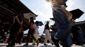 Passersby holding umbrellas walk under a strong sunlight at the Sensoji temple as Japanese government issued heat stroke alerts in 39 of the country's 47 prefectures in Tokyo, Japan July 22, 2024.  REUTERS/Issei Kato