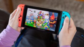IBBENBUEREN, GERMANY - FEBRUARY 14, 2021: Super Mario 3D world popular Nintendo switch with joy controllers family friend activity in a living room