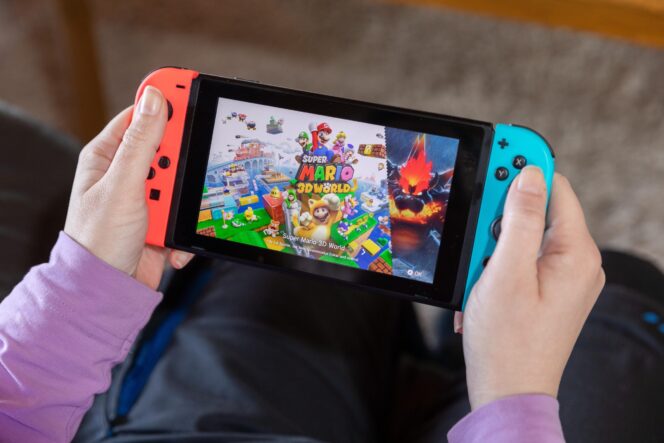 
					IBBENBUEREN, GERMANY - FEBRUARY 14, 2021: Super Mario 3D world popular Nintendo switch with joy controllers family friend activity in a living room