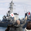 People wave as Japan's Maritime Self-Defence Force destroyer 