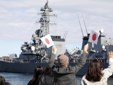 People wave as Japan's Maritime Self-Defence Force destroyer 