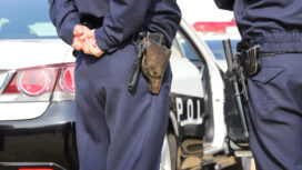 Kagawa, Japan - January 8, 2019: Back view of Japanese police officer with patrol car, in Kagawa, Japan.