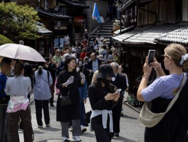 Tourists walk along a street in Kyoto, Japan, on Saturday, April 13, 2024. The yen dropped to a three-decade low against the dollar this week on prospects that despite the BOJs policy shift, yield differentials will remain wide between Japan and the US. Photographer: Buddhika Weerasinghe/Bloomberg