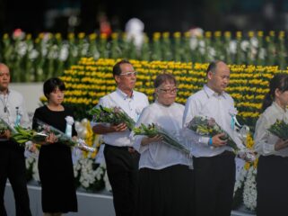 Visitors offer flowers to Hiroshima Memorial Cenotaph during the ceremony to mark the 80th anniversary of the bombing at the Hiroshima Peace Memorial Park in Hiroshima, western Japan, Wednesday, Aug. 6, 2025. (AP Photo/Louise Delmotte)