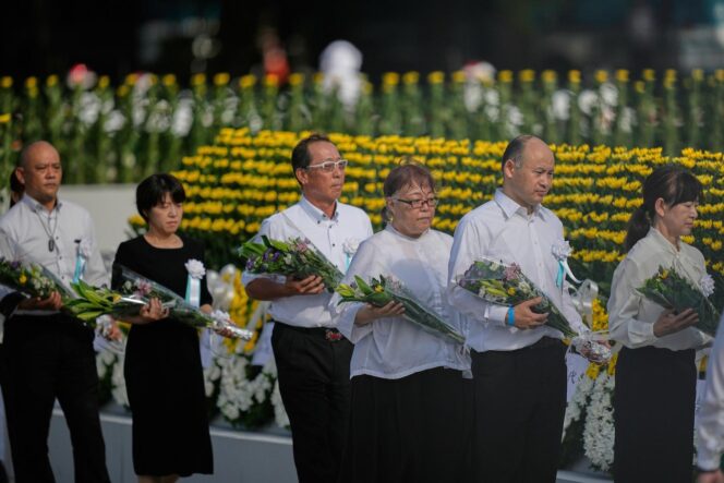 
					Visitors offer flowers to Hiroshima Memorial Cenotaph during the ceremony to mark the 80th anniversary of the bombing at the Hiroshima Peace Memorial Park in Hiroshima, western Japan, Wednesday, Aug. 6, 2025. (AP Photo/Louise Delmotte)