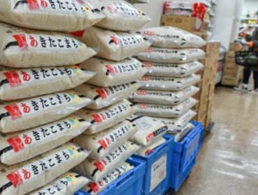 (FILES) This file photo taken on November 22, 2024 shows bags of rice stacked in a supermarket in central Tokyo. The Japanese government said on February 14, 2025 it will release its stockpile of rice -- the nation's cherished staple food -- reserved for emergency use in response to soaring prices. (Photo by Richard A. Brooks / AFP)