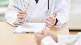 Hands of a male doctor explaining symptoms to the patient