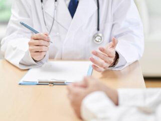 Hands of a male doctor explaining symptoms to the patient