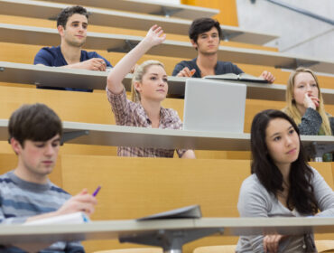 Students taking an active part in a lesson while sitting in a lecture hall
