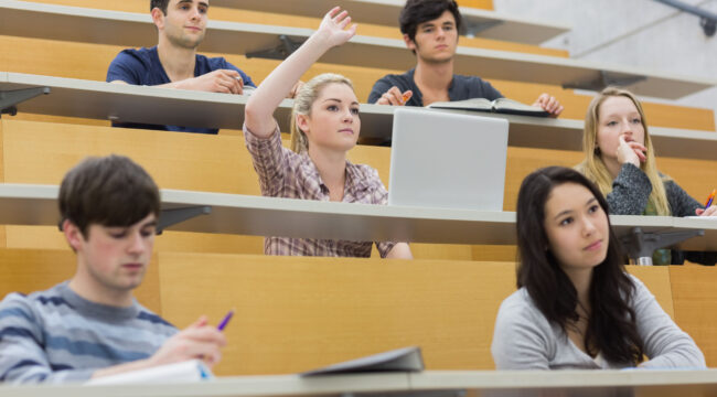 Students taking an active part in a lesson while sitting in a lecture hall