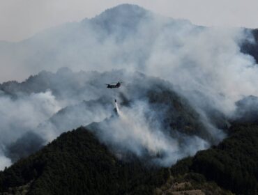 A helicopter conducts firefighting operations as wildfires continue in Otsuchi, Iwate Prefecture, Japan, April 26, 2026. REUTERS/Kim Kyung-Hoon
