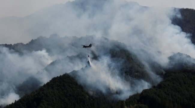 A helicopter conducts firefighting operations as wildfires continue in Otsuchi, Iwate Prefecture, Japan, April 26, 2026. REUTERS/Kim Kyung-Hoon