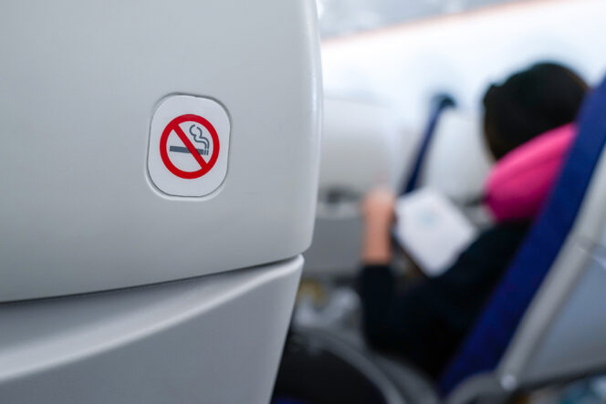 
					no smoking sign on plane seat.
