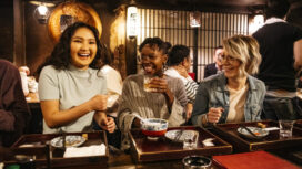 Young women laughing on night out, food and drink, bonding, carefree