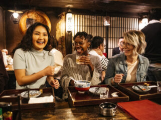 Young women laughing on night out, food and drink, bonding, carefree