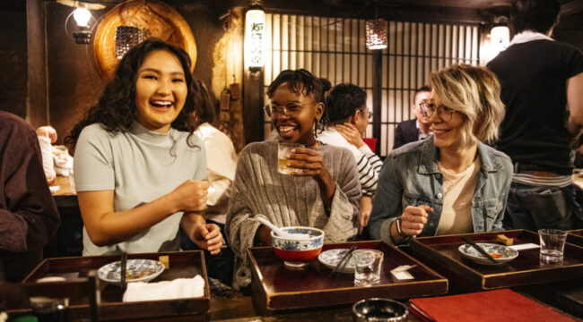 Young women laughing on night out, food and drink, bonding, carefree