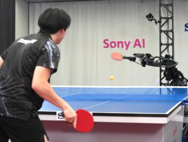 A table tennis robot built by Sony maneuvers to hit the ball back to its human opponent, Akito Saeki, during a match in Tokyo, Dec. 2025. (Sony AI via AP)