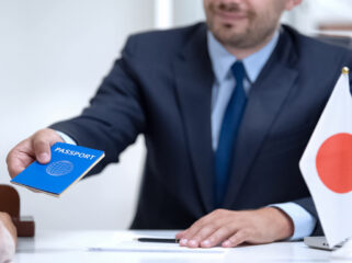 Japan consular officer giving passport to young woman, student visa approval