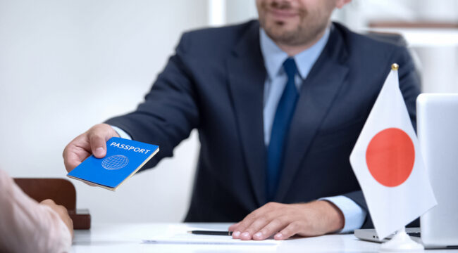 Japan consular officer giving passport to young woman, student visa approval
