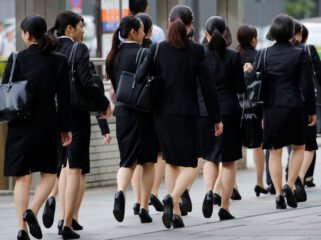 Female office workers wearing high heels, clothes and bags of the same colour make their way at a business district in Tokyo, Japan, June 4, 2019. REUTERS/Kim Kyung-Hoon