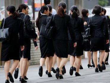 Female office workers wearing high heels, clothes and bags of the same colour make their way at a business district in Tokyo, Japan, June 4, 2019. REUTERS/Kim Kyung-Hoon
