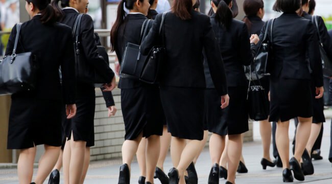 Female office workers wearing high heels, clothes and bags of the same colour make their way at a business district in Tokyo, Japan, June 4, 2019. REUTERS/Kim Kyung-Hoon